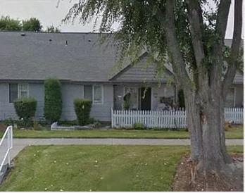 a white house with a tree and a white picket fence